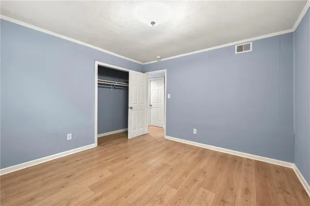 a view of an empty room with wooden floor