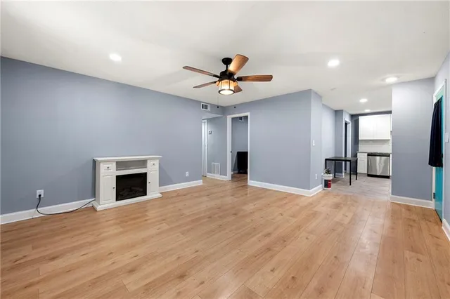 a view of empty room with wooden floor and a ceiling fan