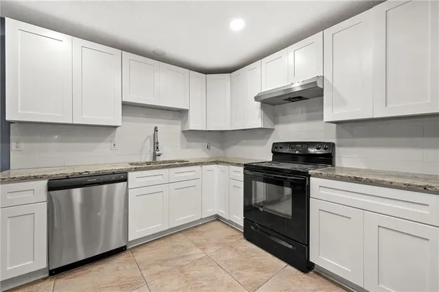 a kitchen with white cabinets stainless steel appliances and sink
