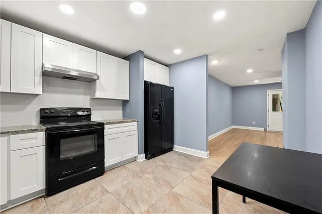 a kitchen with stainless steel appliances granite countertop a refrigerator and a stove top oven