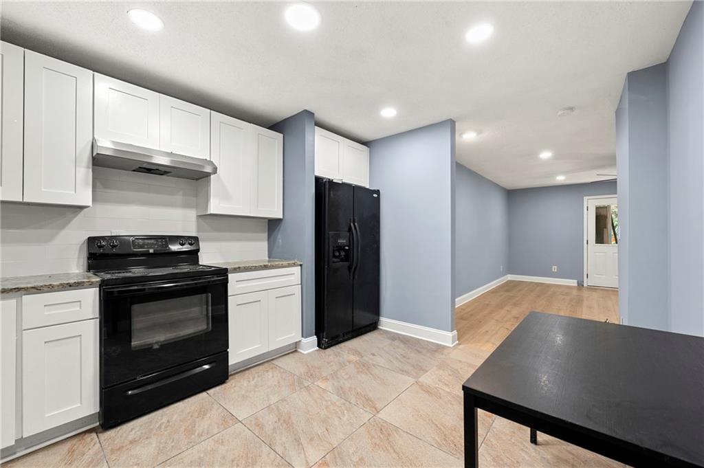 6708 Baynes Hill Circle Clarkston, GA 30021 - Photo 6 of 17 a kitchen with stainless steel appliances granite countertop a refrigerator and a stove top oven