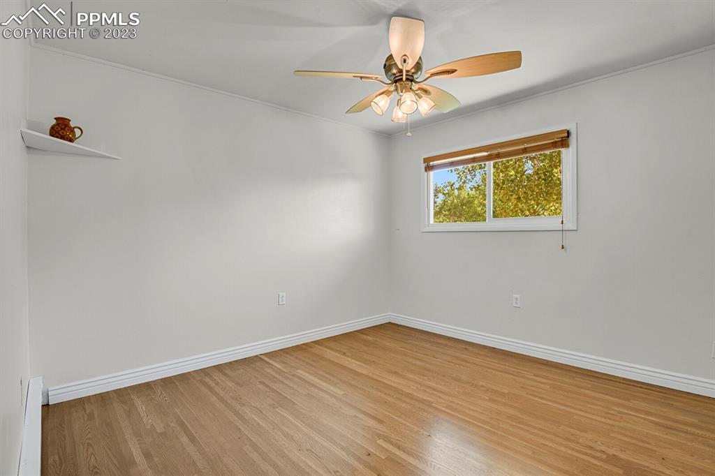 286 Ridge Road Divide, CO 80814 - Photo 13 of 27 a view of an empty room with wooden floor and a chandelier fan