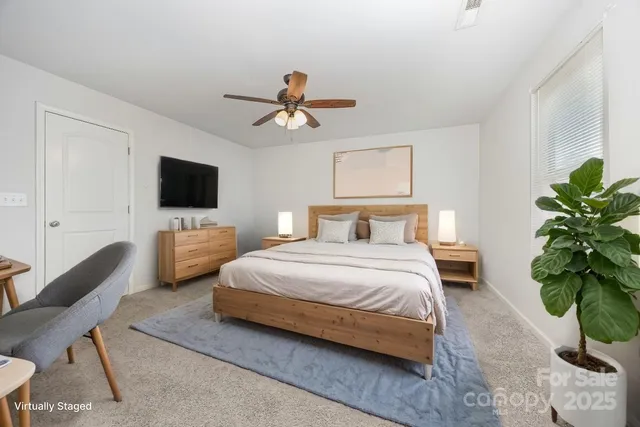 a bedroom with a bed window and a flat screen tv