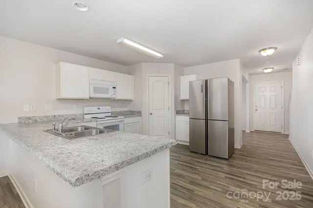 a kitchen with a refrigerator a sink and wooden cabinets