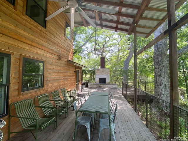 a view of a patio with table and chairs with wooden floor and fence