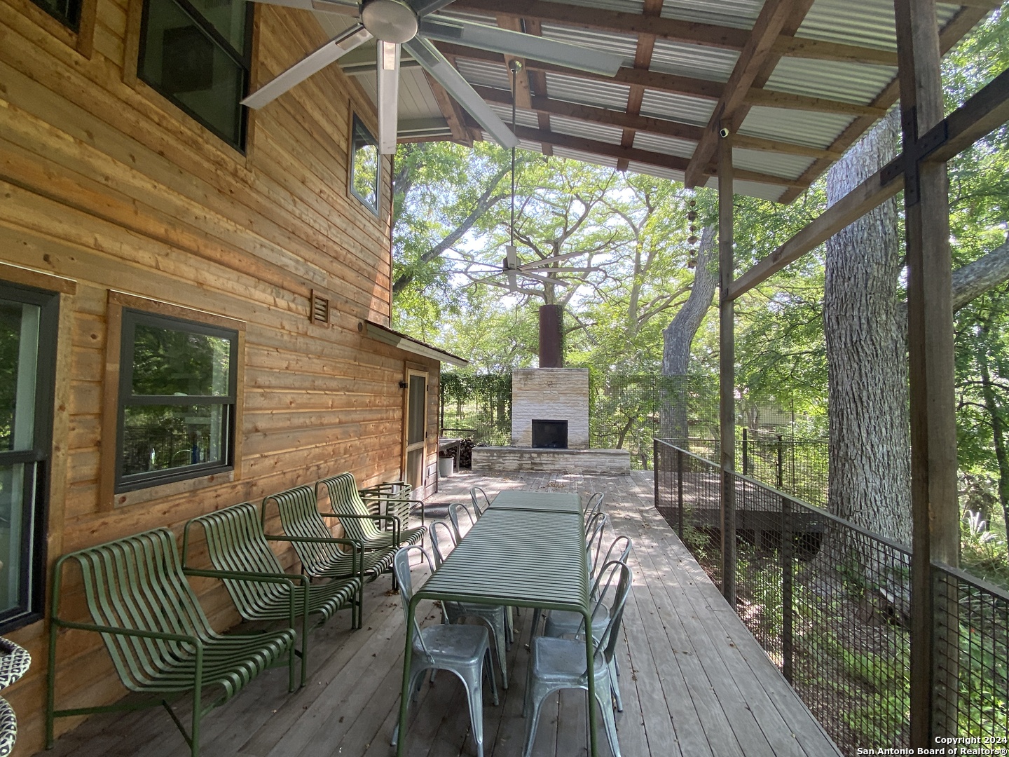 a view of a patio with table and chairs with wooden floor and fence