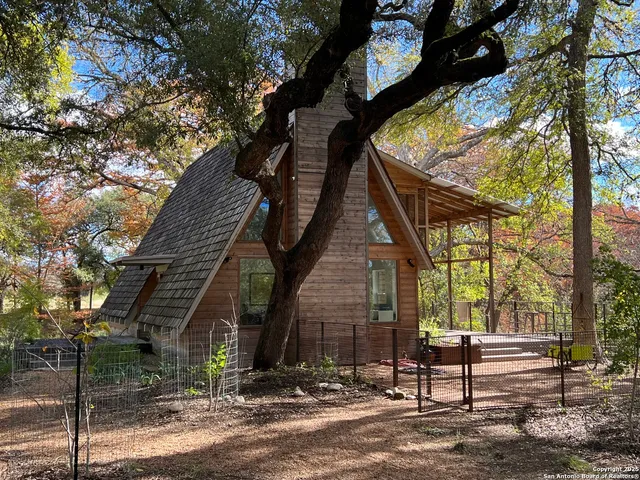 a view of a house with a tree next to a yard