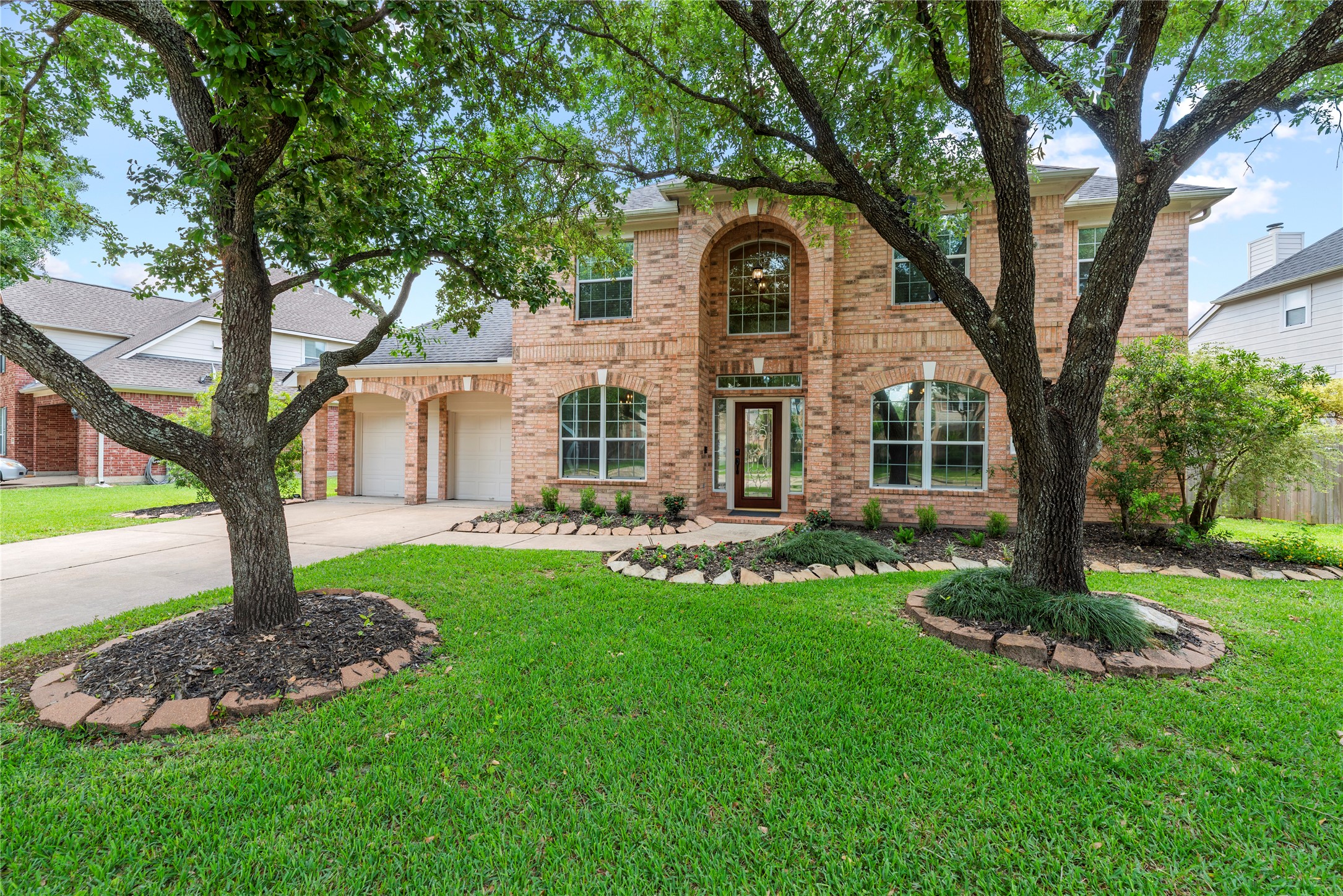 7930 Chateau Point Lane Houston, TX 77041 - Photo 3 of 34 Beautiful curb appeal for this two-story brick home. The front yard features mature trees and well-maintained landscaping. The property includes a 3-car garage and a spacious driveway, offering ample parking.