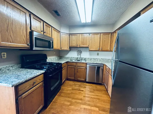a kitchen with stainless steel appliances granite countertop a stove sink microwave and cabinets