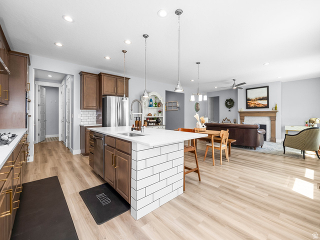 877 South Yarrow Drive Mapleton, UT 84664 - Photo 9 of 46 Open-concept kitchen and living area featuring wood-finish flooring, recessed lighting, and a kitchen island with white subway tile