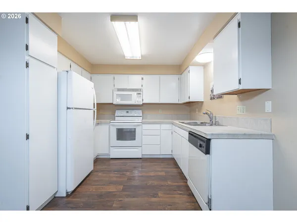 a kitchen with stainless steel appliances granite countertop a refrigerator sink and white cabinets