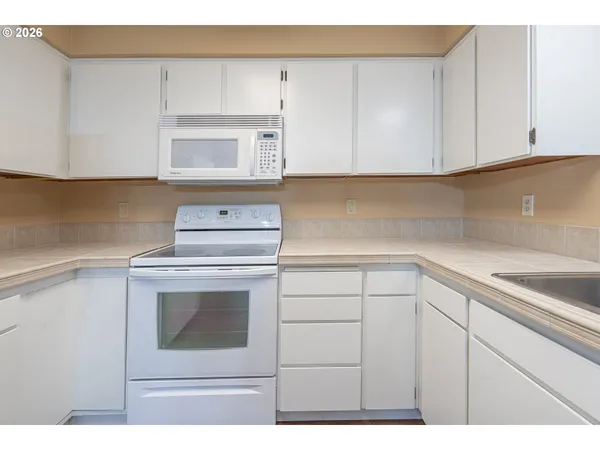 a kitchen with white cabinets stainless steel appliances and sink