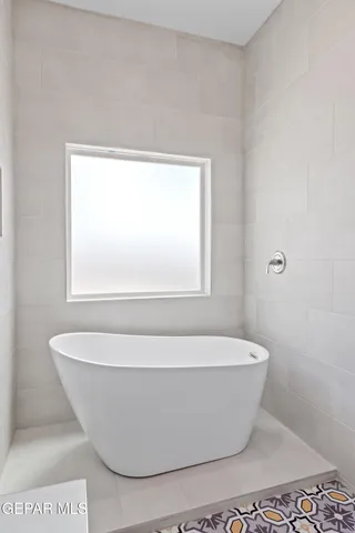 a white tub sitting next to a window