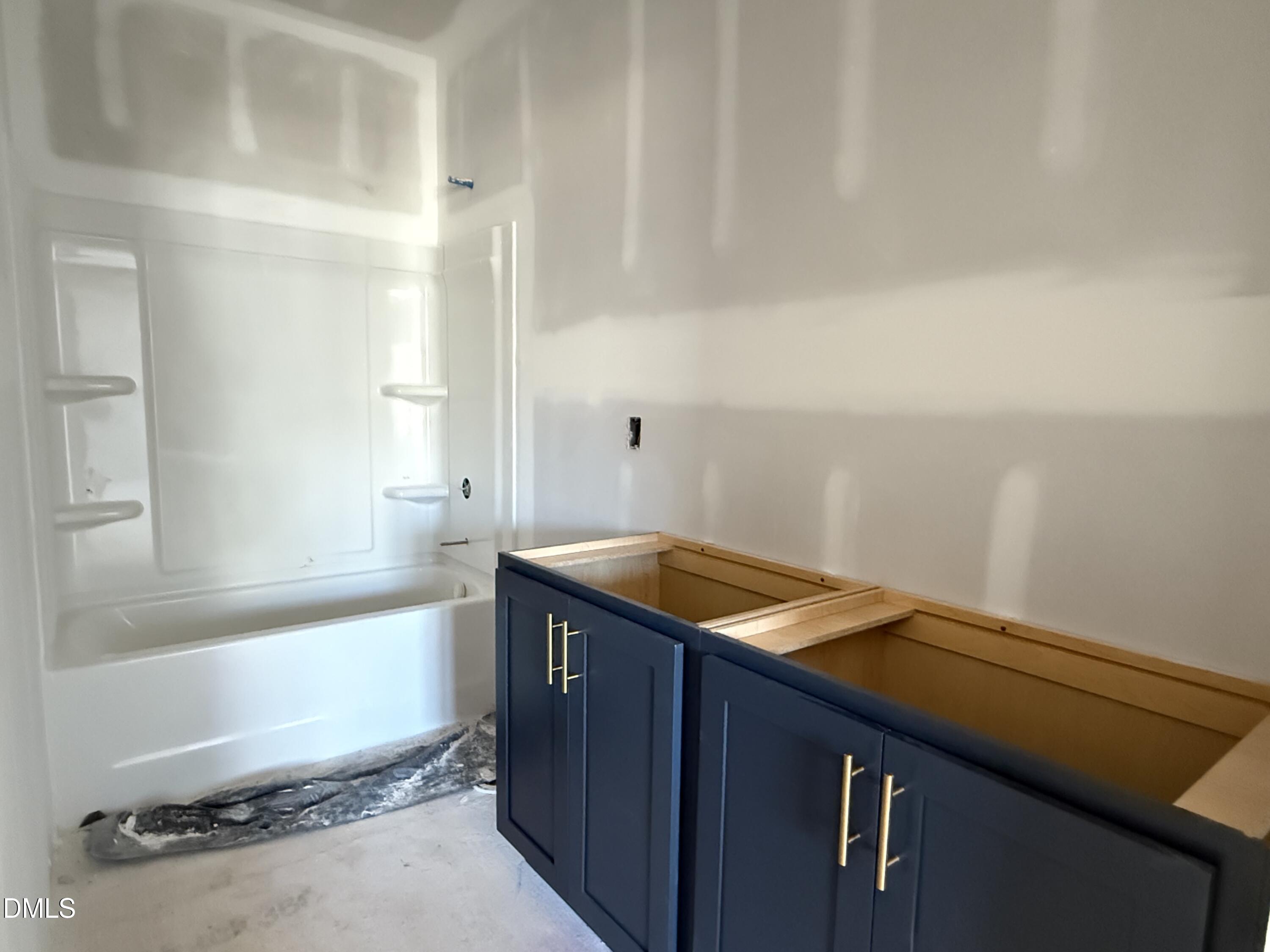 2205 Seraphic Way, Unit 403 Rolesville, NC 27571 - Photo 16 of 41 a bathroom with a granite countertop sink and a bathtub