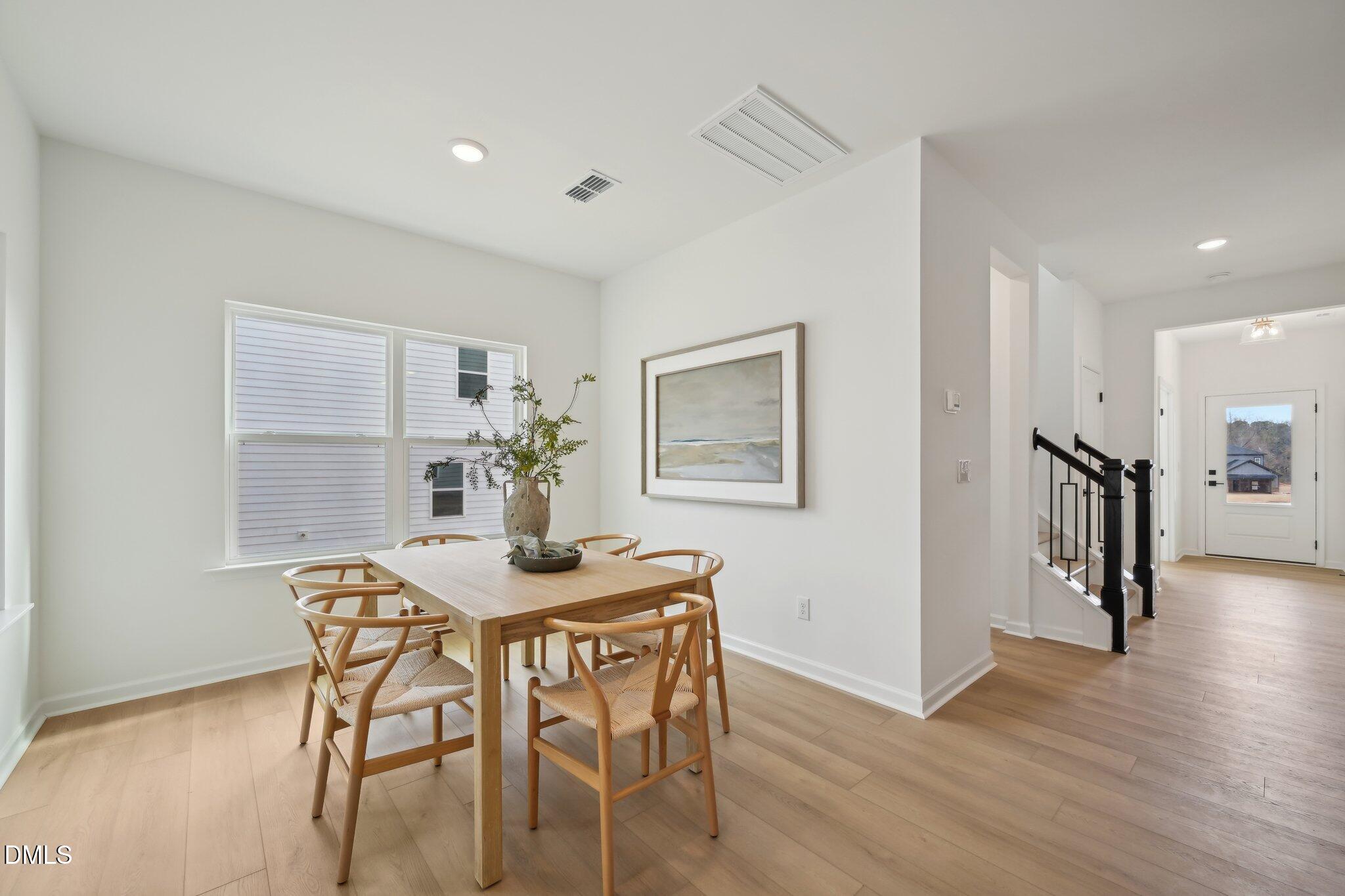 2205 Seraphic Way, Unit 403 Rolesville, NC 27571 - Photo 27 of 41 a dining room with furniture and wooden floor