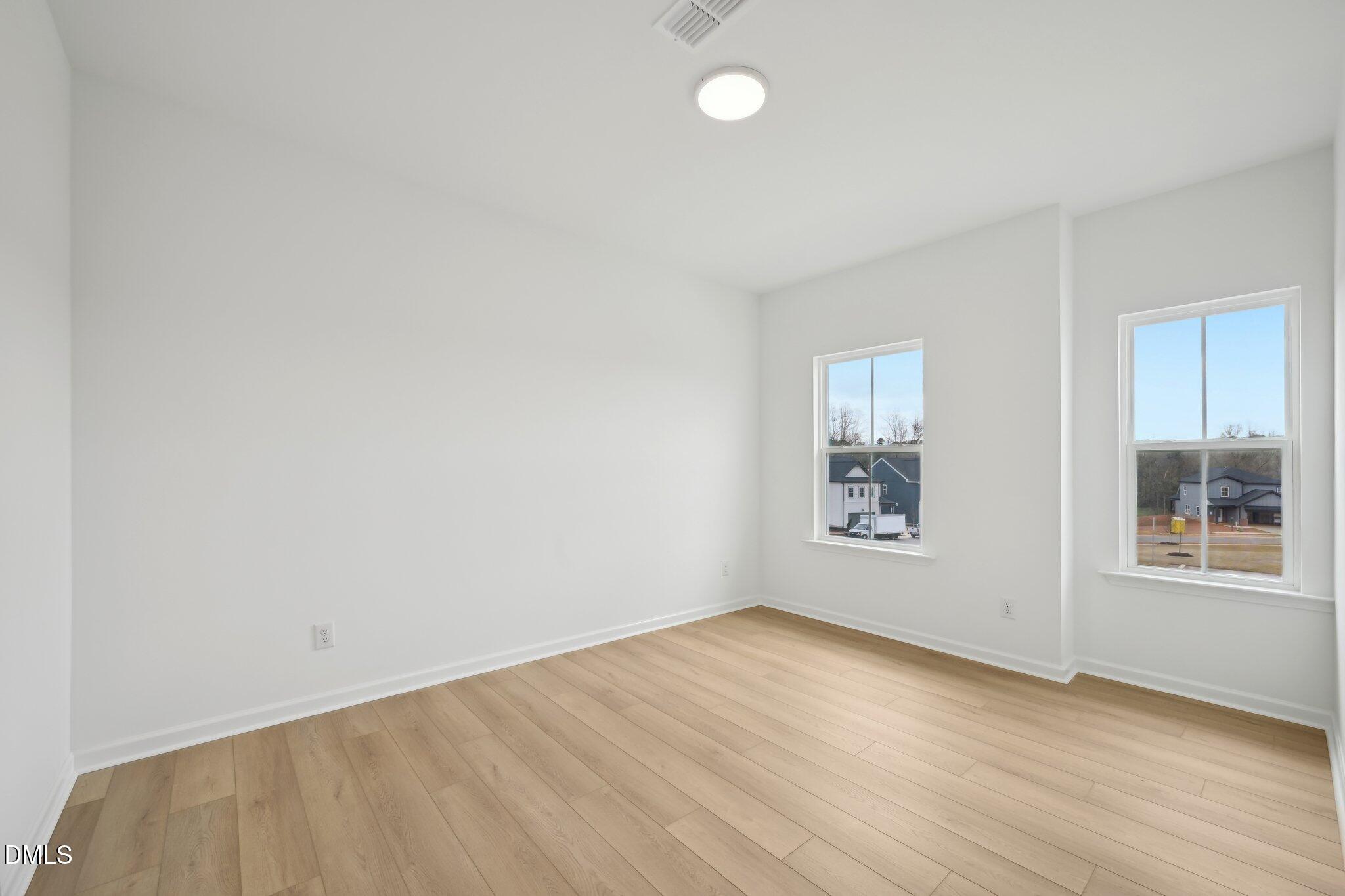 2205 Seraphic Way, Unit 403 Rolesville, NC 27571 - Photo 35 of 41 an empty room with wooden floor and windows