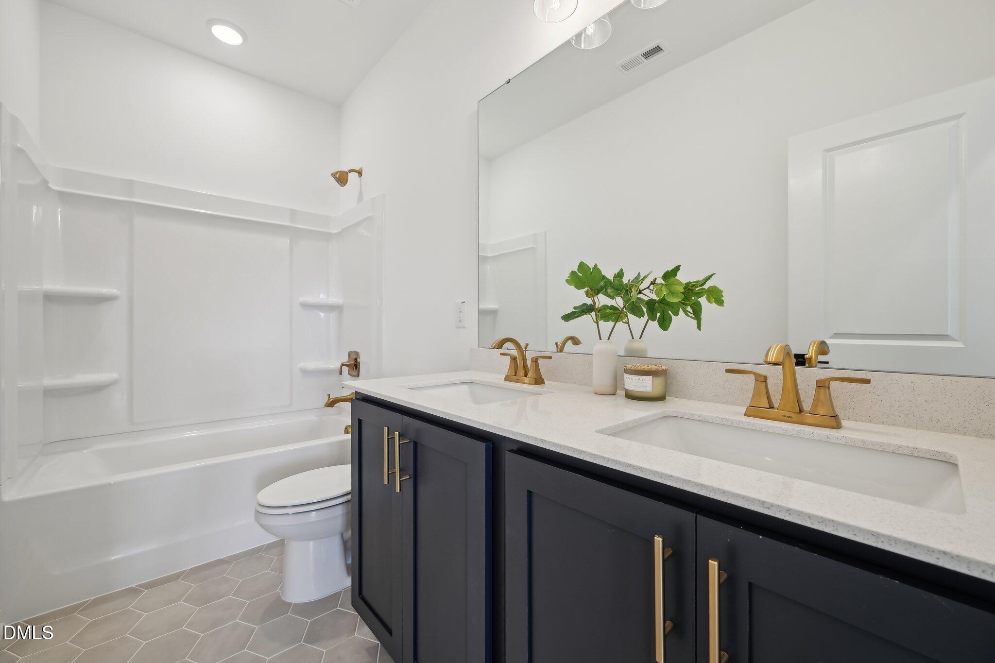 2205 Seraphic Way, Unit 403 Rolesville, NC 27571 - Photo 41 of 41 a bathroom with a granite countertop sink a toilet and bathtub
