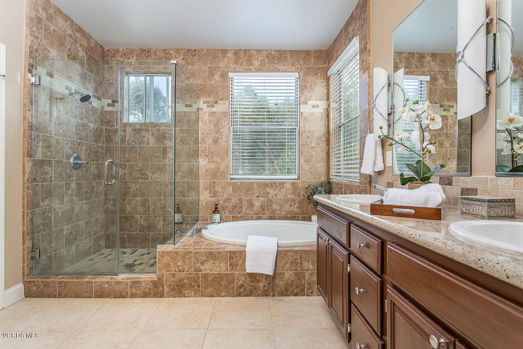 11249 Shadyridge Road Moorpark, CA 93021 - Photo 24 of 48 a bathroom with a granite countertop sink a mirror and a bathtub