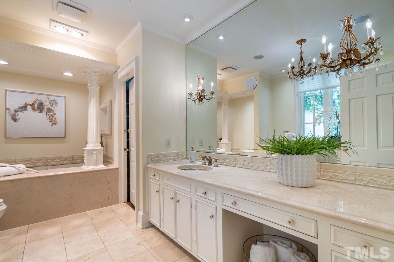 903 Wakestone Court Raleigh, NC 27609 - Photo 20 of 40 a spacious bathroom with a granite countertop sink a large mirror and a bathtub