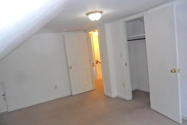 an empty room with closet and mirror