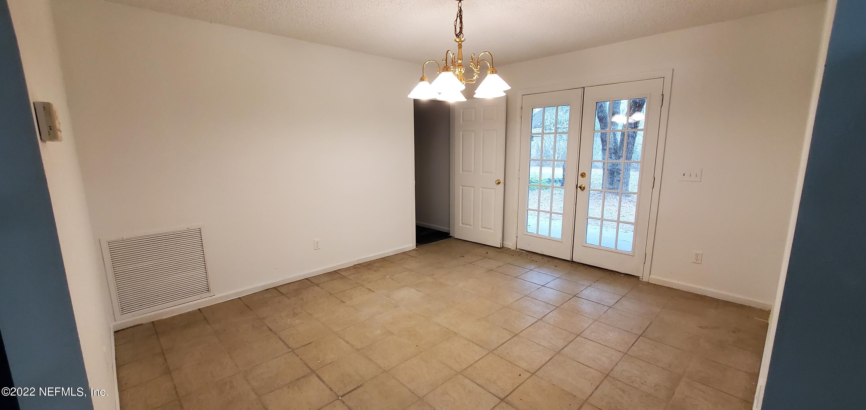 3578 Hamp Hicks Road Bryceville, FL 32009 - Photo 5 of 16 an empty room with chandelier fan and glass door