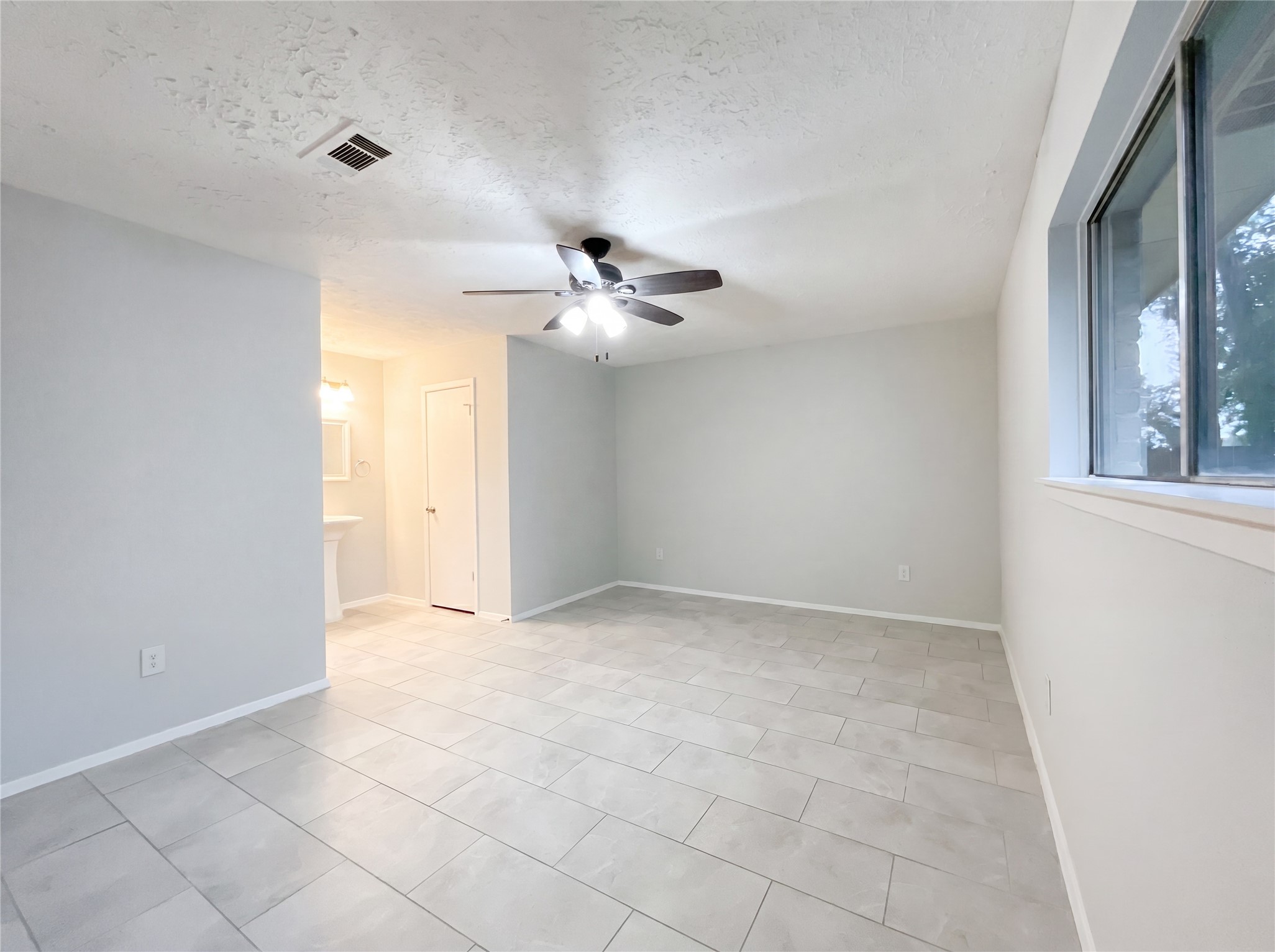 23110 Pennsgrove Road Spring, TX 77373 - Photo 10 of 16 an empty room with a chandelier fan and windows