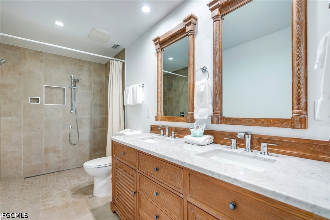 128 Useppa Island Useppa Island, FL 33922 - Photo 28 of 50 a bathroom with a granite countertop double vanity sink mirror and shower