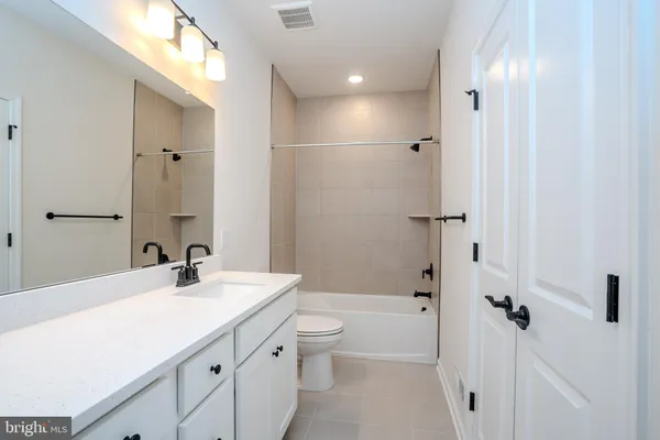 a bathroom with a sink a toilet a mirror and shower