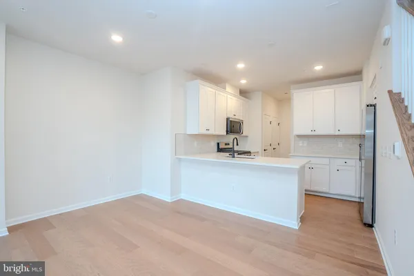 a kitchen with a refrigerator and white cabinets