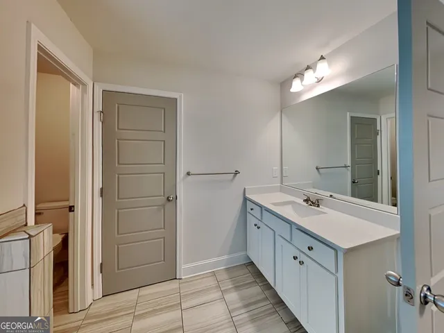 a spacious bathroom with a double vanity sink a mirror and a shower