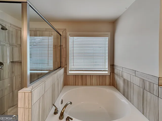 a bathroom with bathtub and window