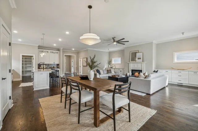 a view of a dining room and livingroom view with furniture wooden floor a rug and a chandelier