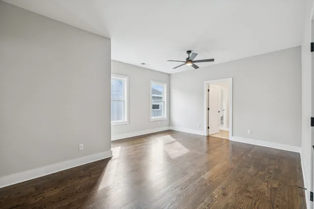 a view of an empty room with a ceiling fan and window