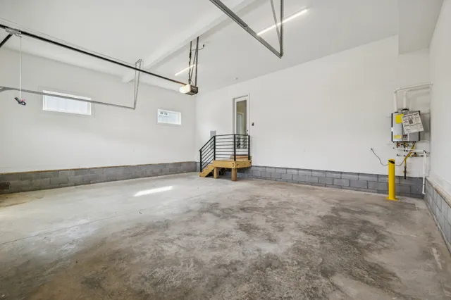 a room with a water heater and wooden cabinets