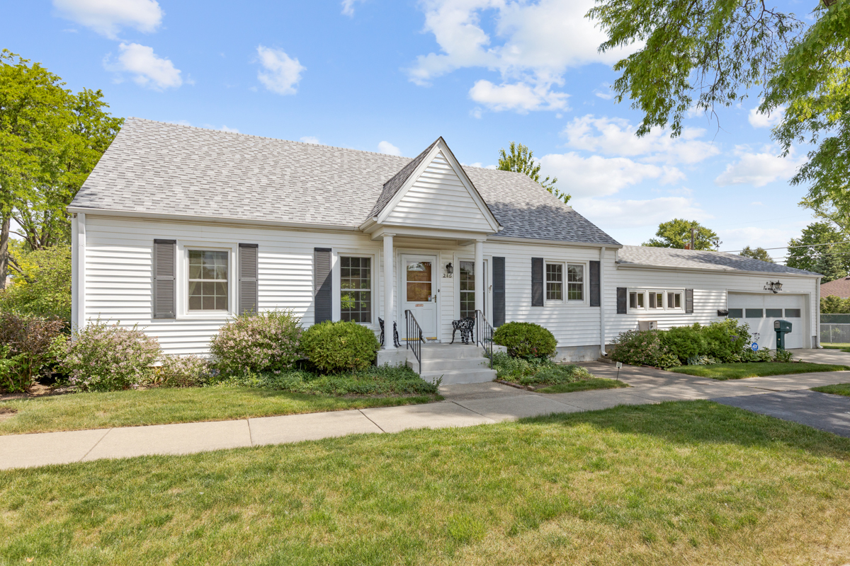 a front view of a house with garden and plants