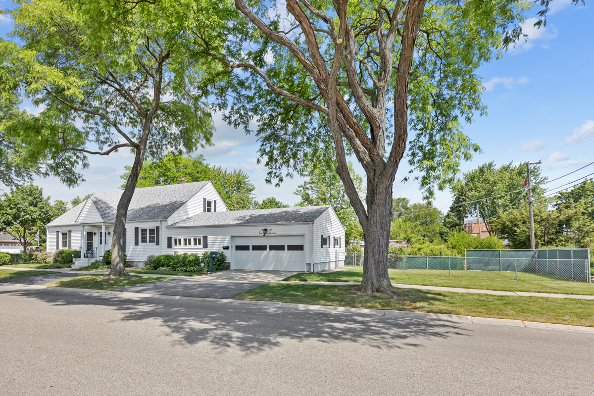 216 Center Avenue Wheeling, IL 60090 - Photo 3 of 25 a front view of a house with a yard and large trees