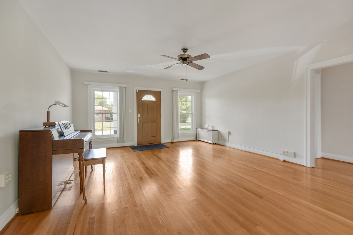 216 Center Avenue Wheeling, IL 60090 - Photo 4 of 25 an empty room with wooden floor and windows