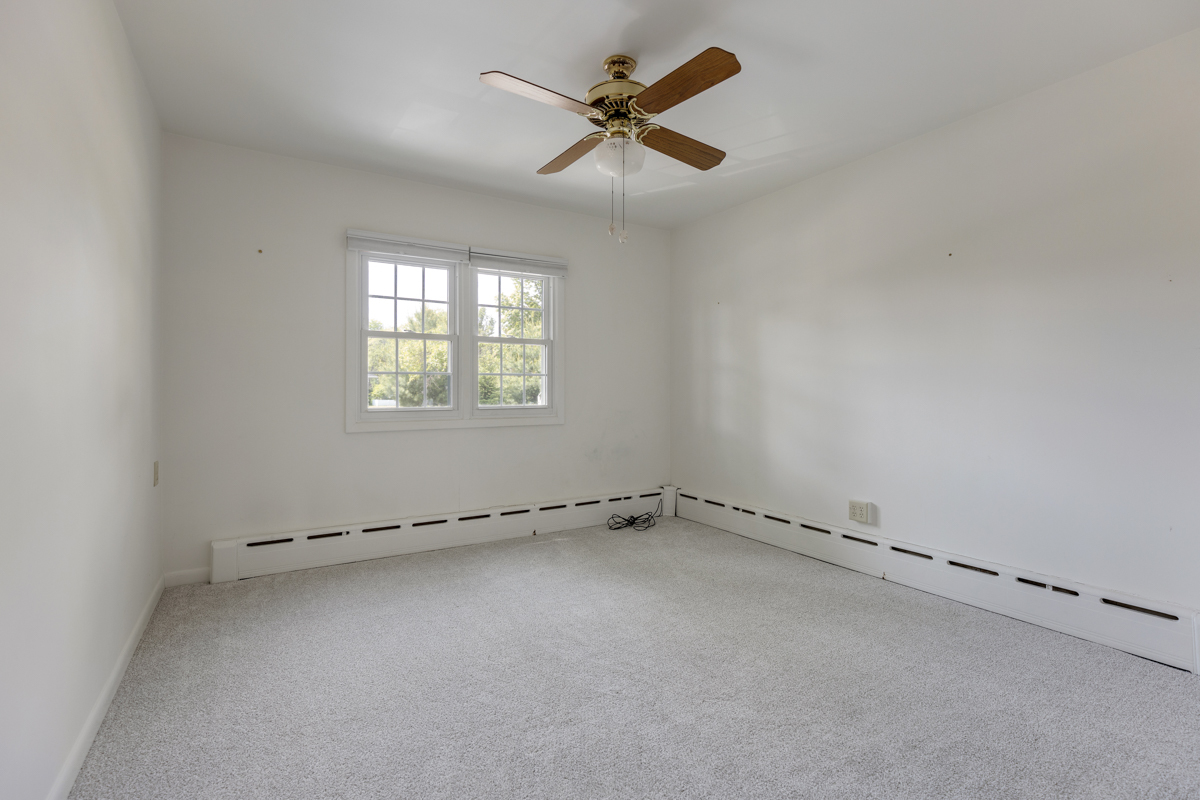 216 Center Avenue Wheeling, IL 60090 - Photo 10 of 25 an empty room with a ceiling fan and a window