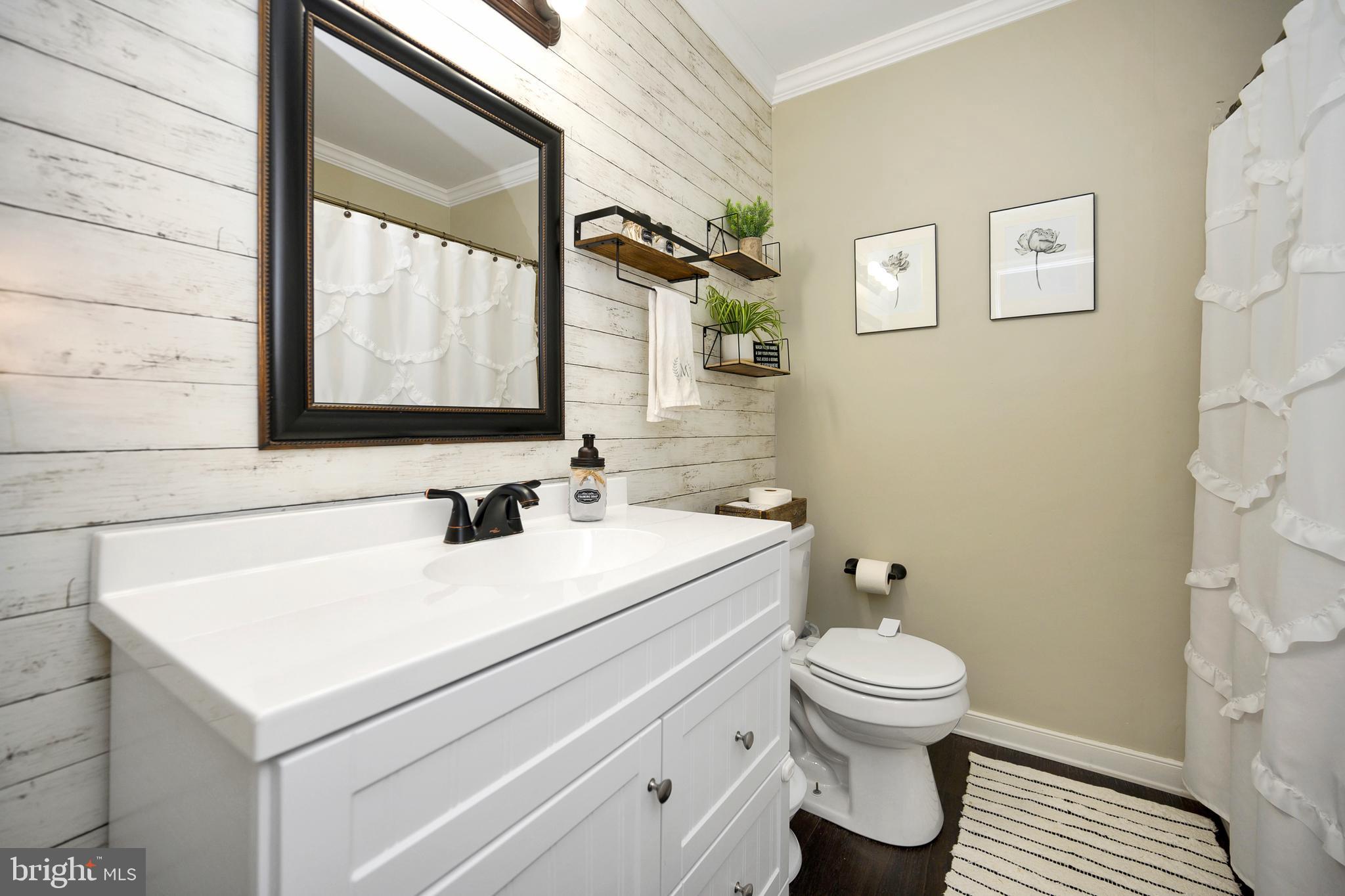 28 Benner Loop Ruther Glen, VA 22546 - Photo 38 of 54 a bathroom with a sink a toilet and a mirror