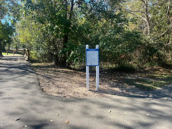 a street sign on a sidewalk next to a road