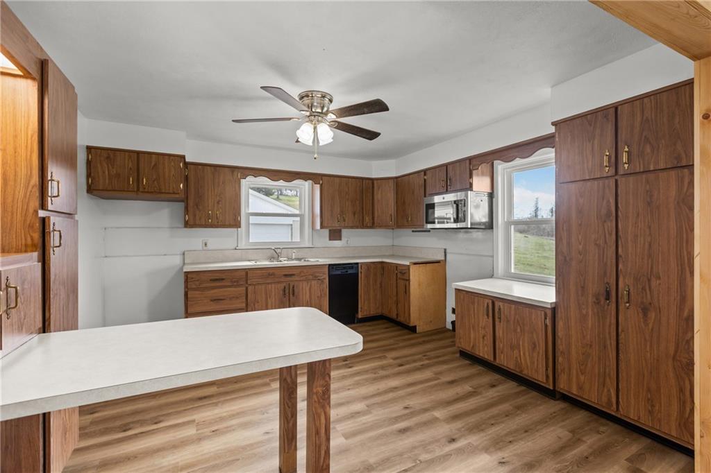 1300 Main Street Bentleyville, PA 15314 - Photo 14 of 36 a kitchen with stainless steel appliances kitchen island granite countertop a stove a sink dishwasher and a refrigerator with wooden floor