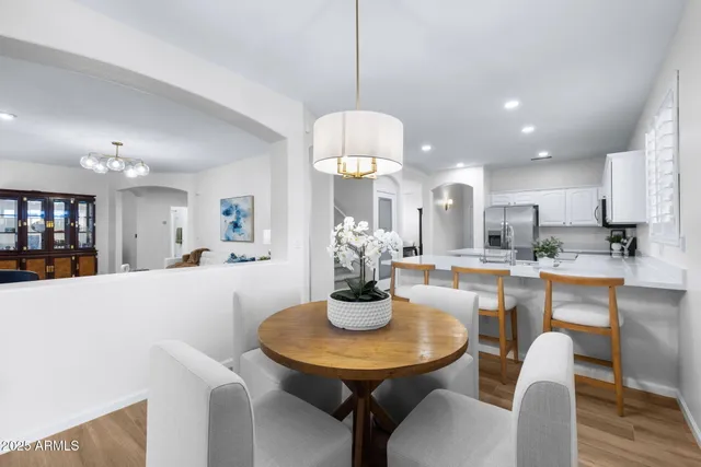 a kitchen with stainless steel appliances kitchen island granite countertop a table and chairs in it