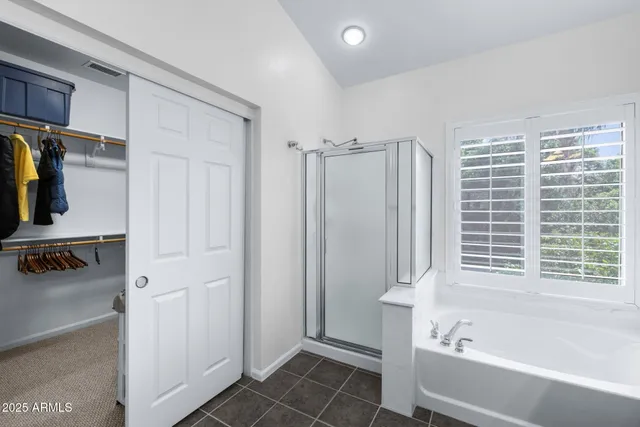 a view of walk in closet with clothes and shoes