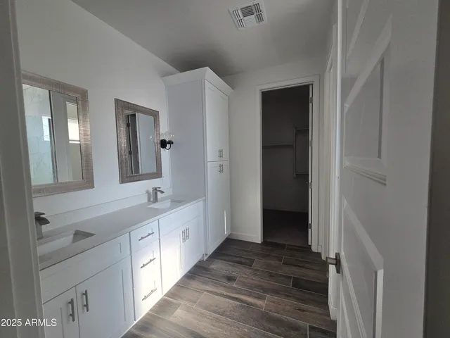a bathroom with a double vanity sink and mirror with shower