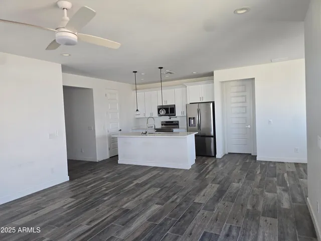 a large kitchen with cabinets wooden floor and stainless steel appliances