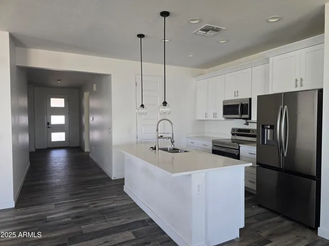 a kitchen with kitchen island a sink stainless steel appliances and cabinets