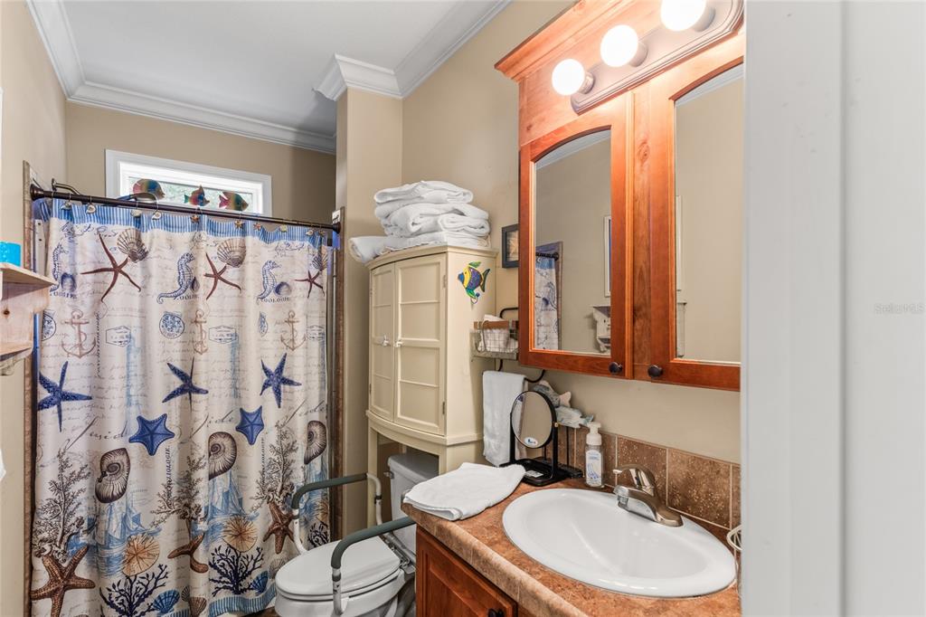 5711 Caribbean Circle Keystone Heights, FL 32656 - Photo 29 of 61 a bathroom with a sink a toilet and shower curtain