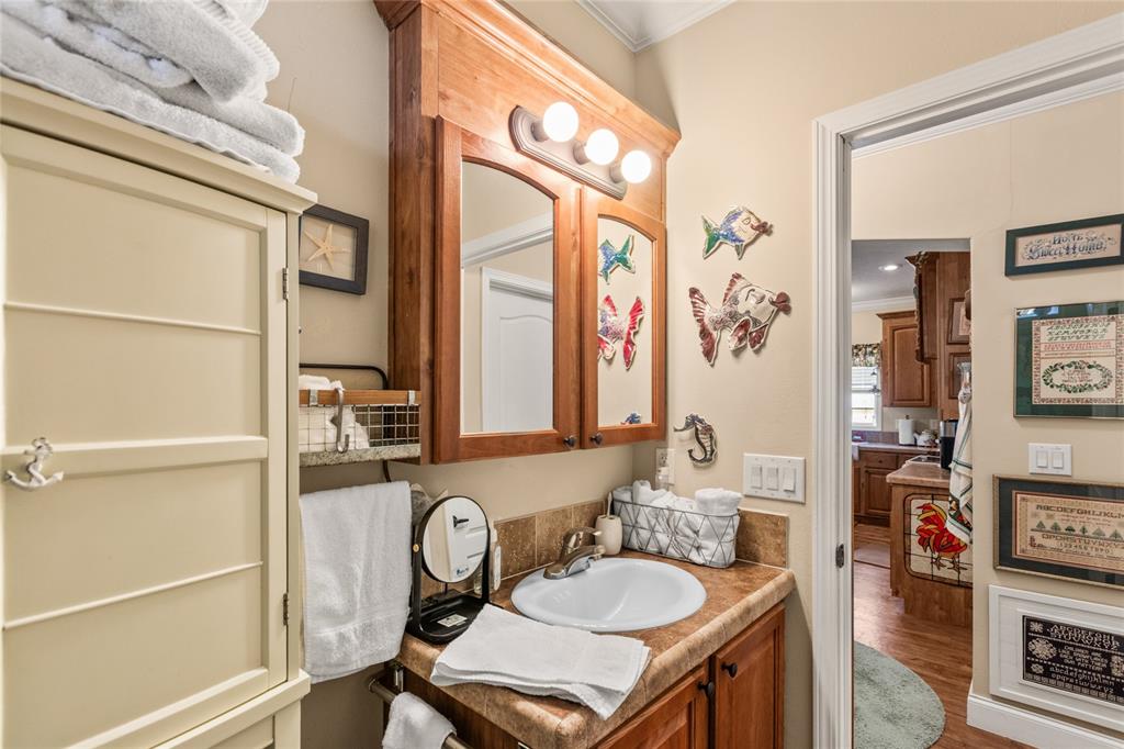 5711 Caribbean Circle Keystone Heights, FL 32656 - Photo 30 of 61 a bathroom with a granite countertop sink a toilet and a mirror