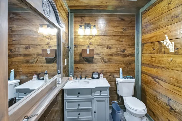 a bathroom with a sink a toilet a mirror and shower