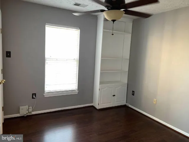an empty room with wooden floor and a window